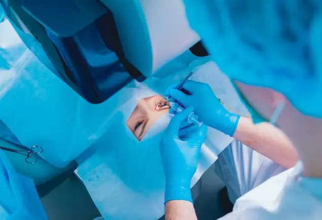 laser-vision-correction-patient-and-team-of-surgeons-in-the-operating-room-during-ophthalmic-surgery-eyelid-speculum-lasik-treatment